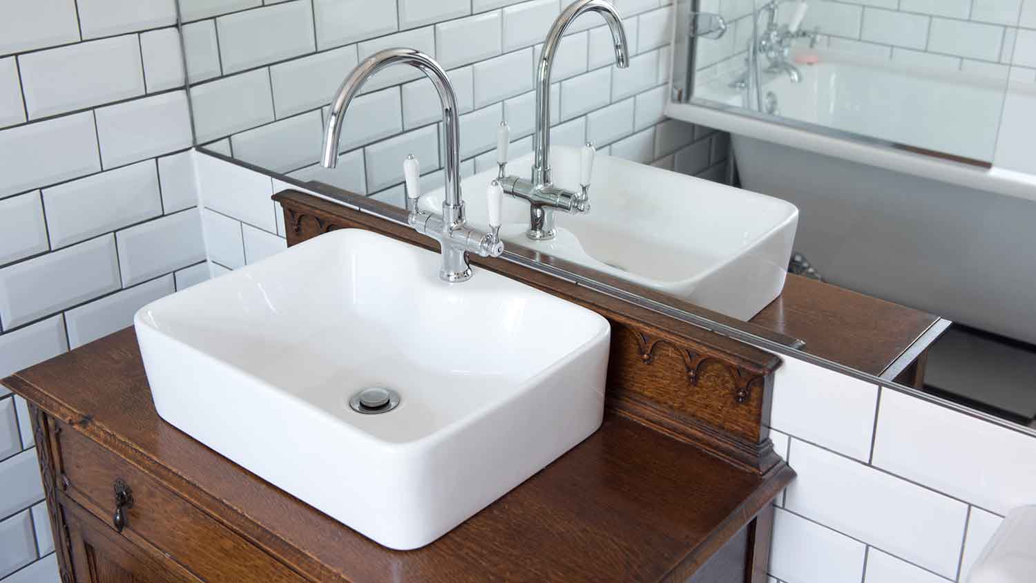 Single bathroom sink sitting on a wooden table