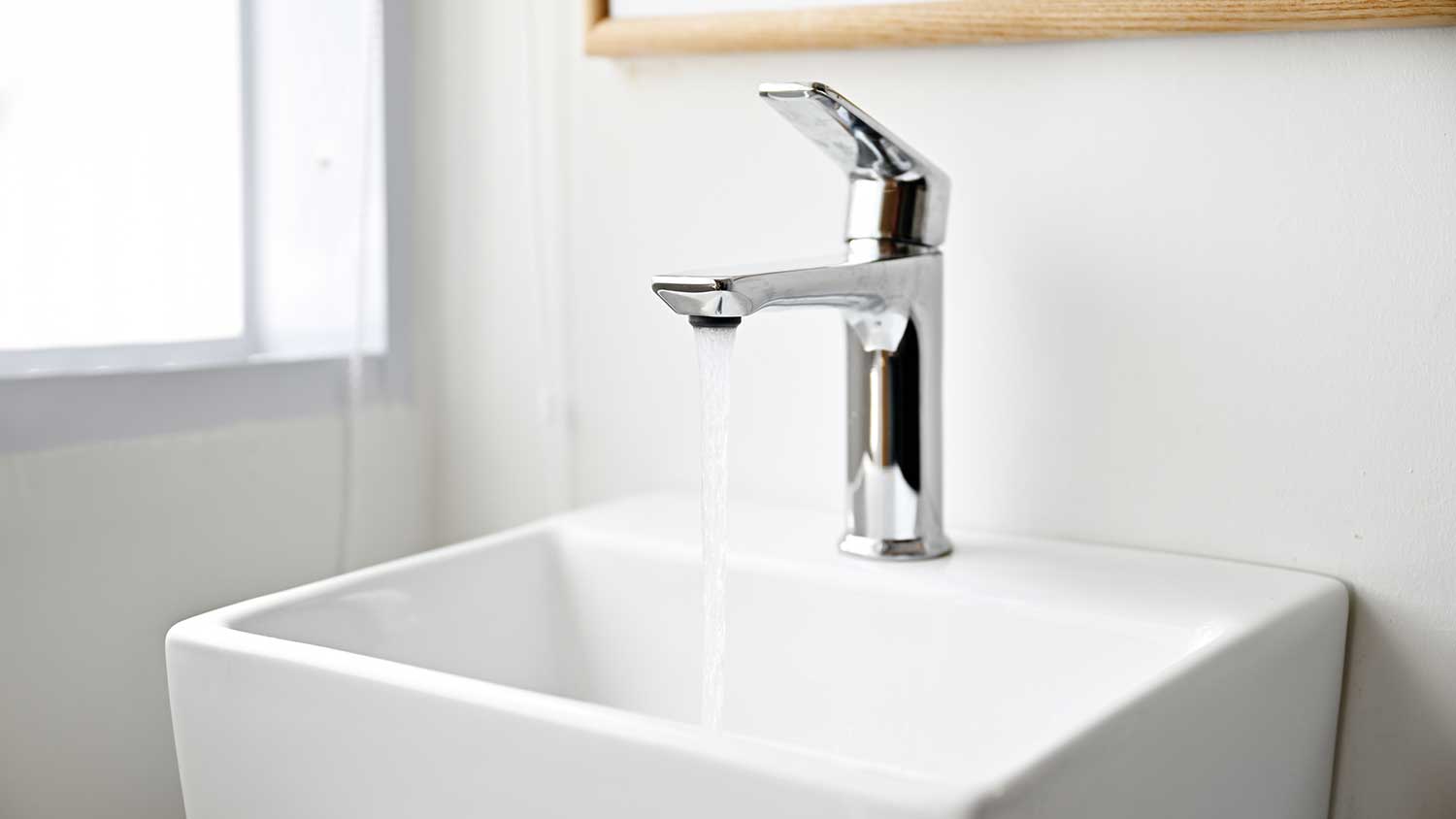 Bathroom sink with single-handle faucet and water running 