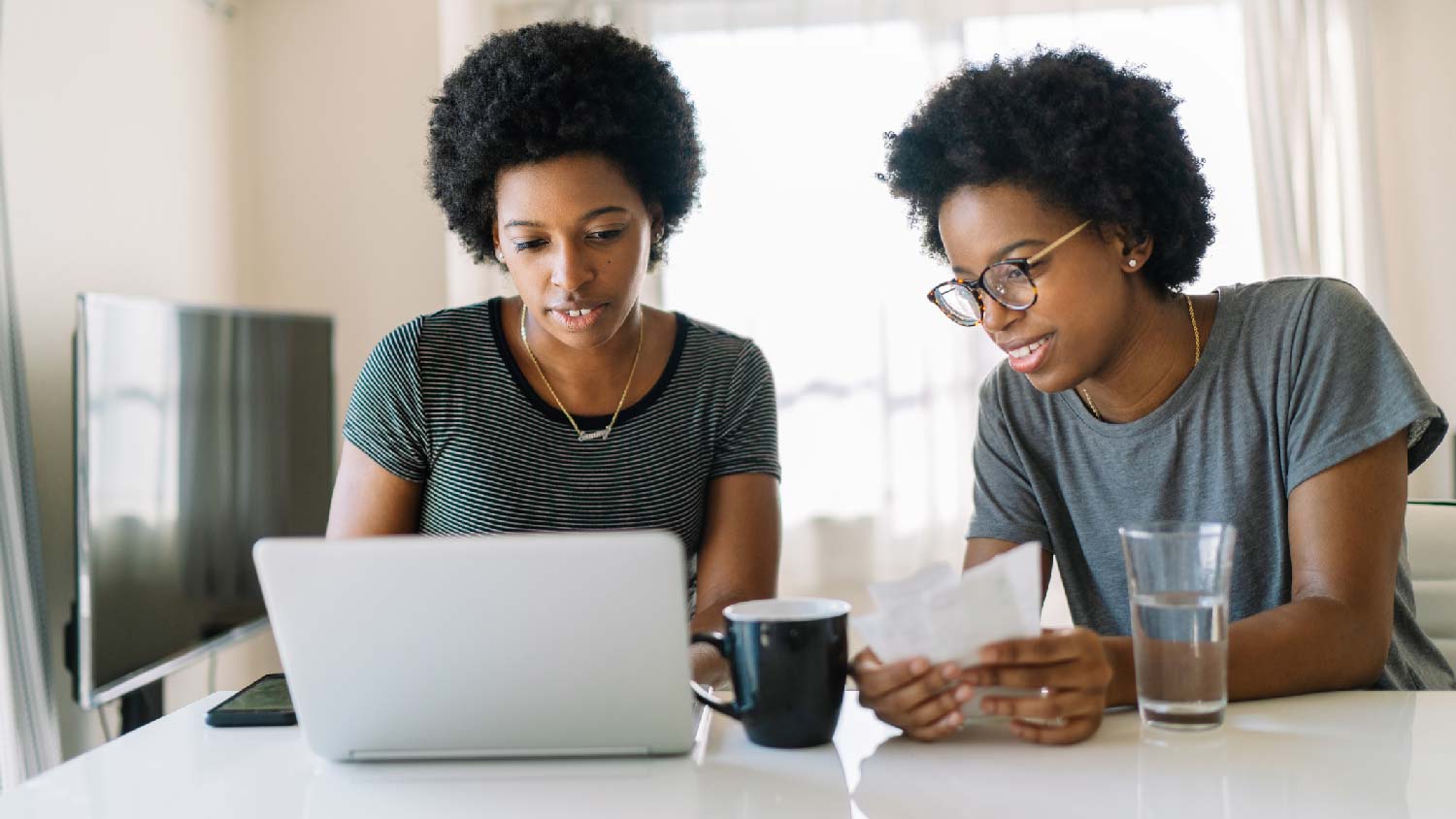 Two sisters checking the water bill