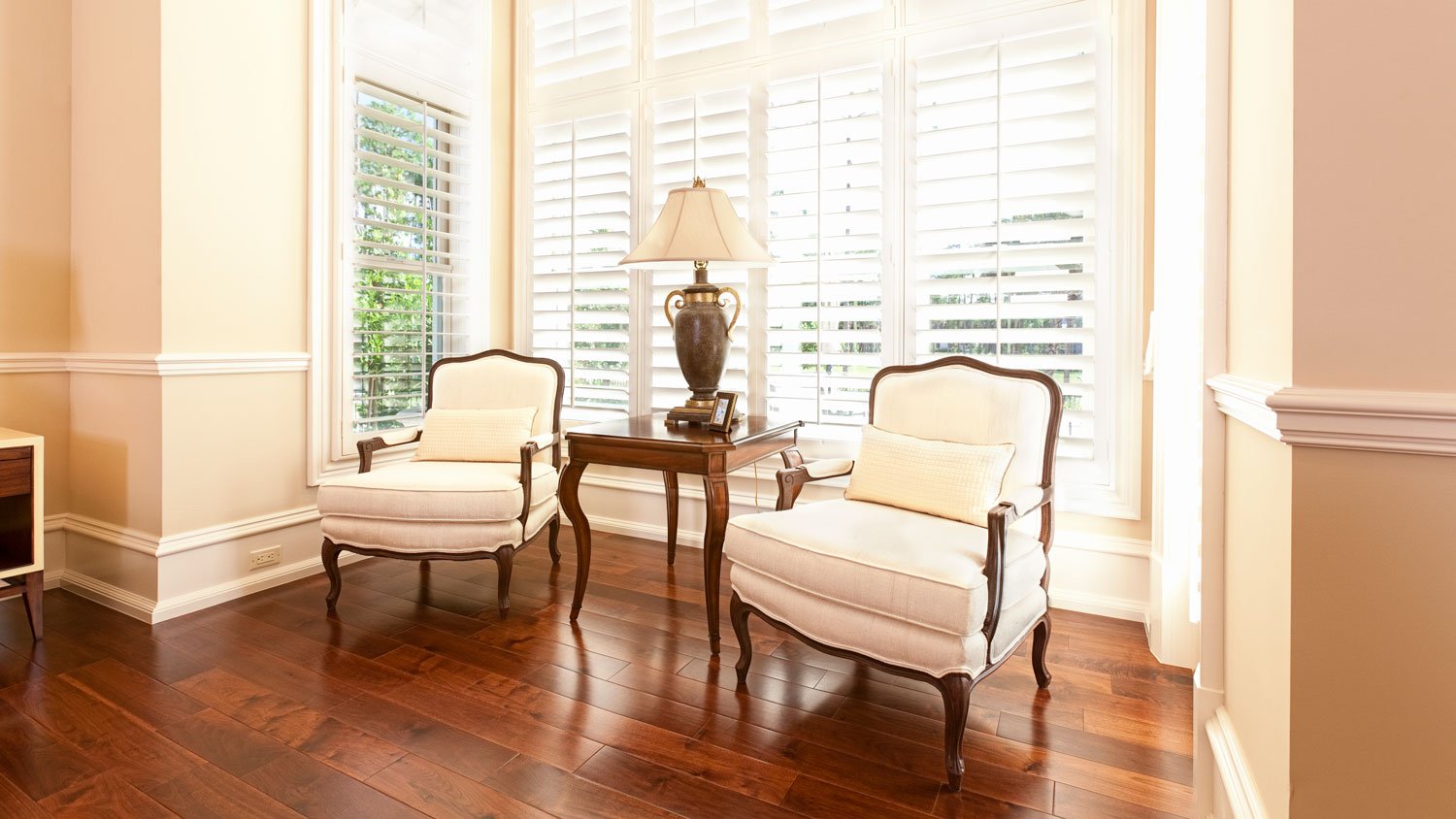 Sitting area with chairs and a window with internal shutters