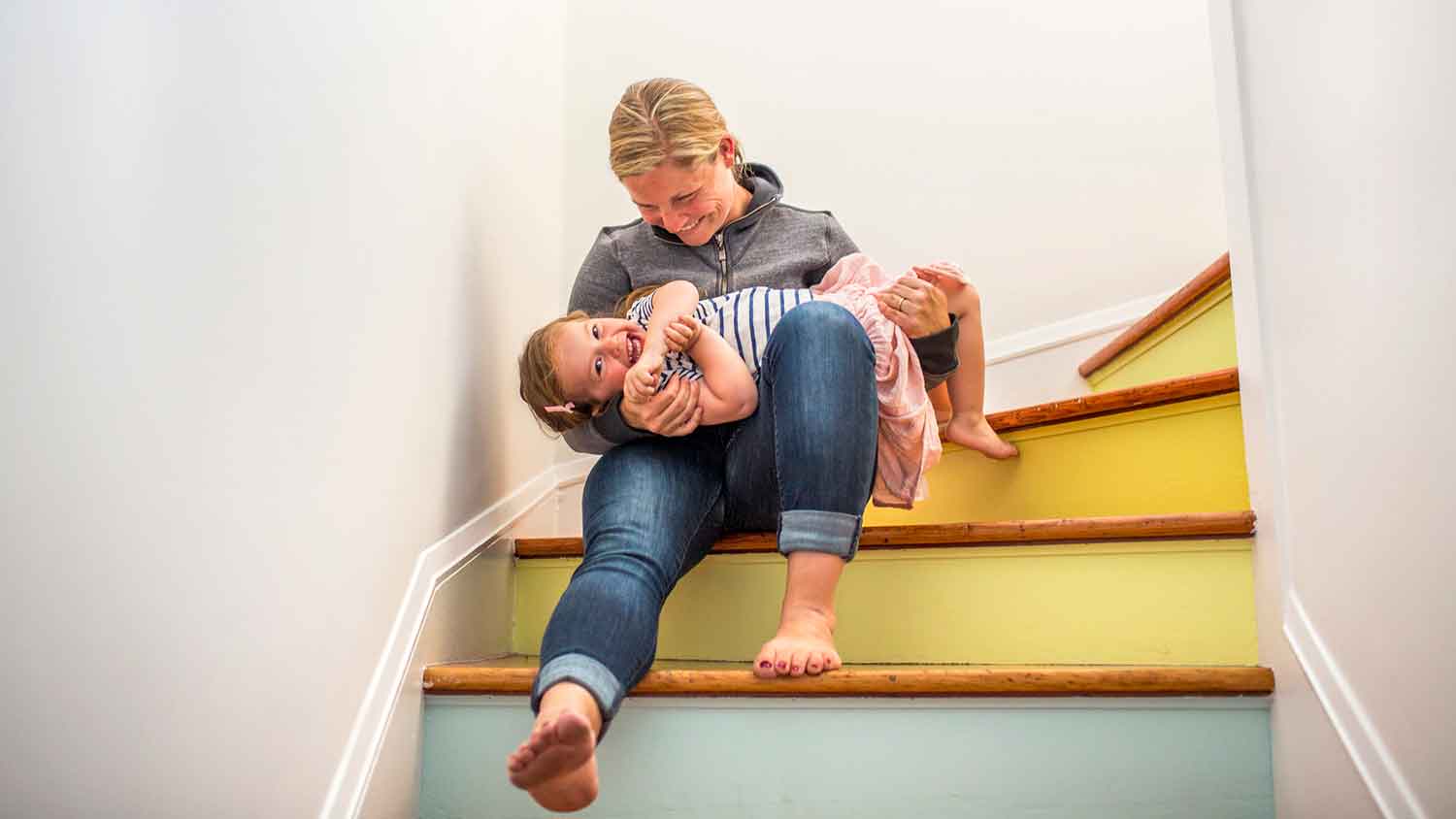 Mother and daughter sitting on a colorful staircase