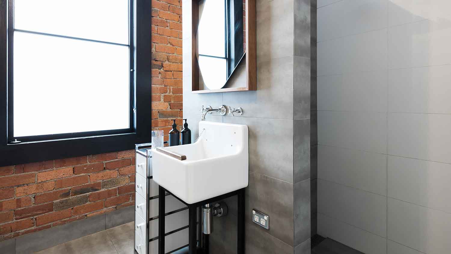 Small console sink installed in industrial style bathroom