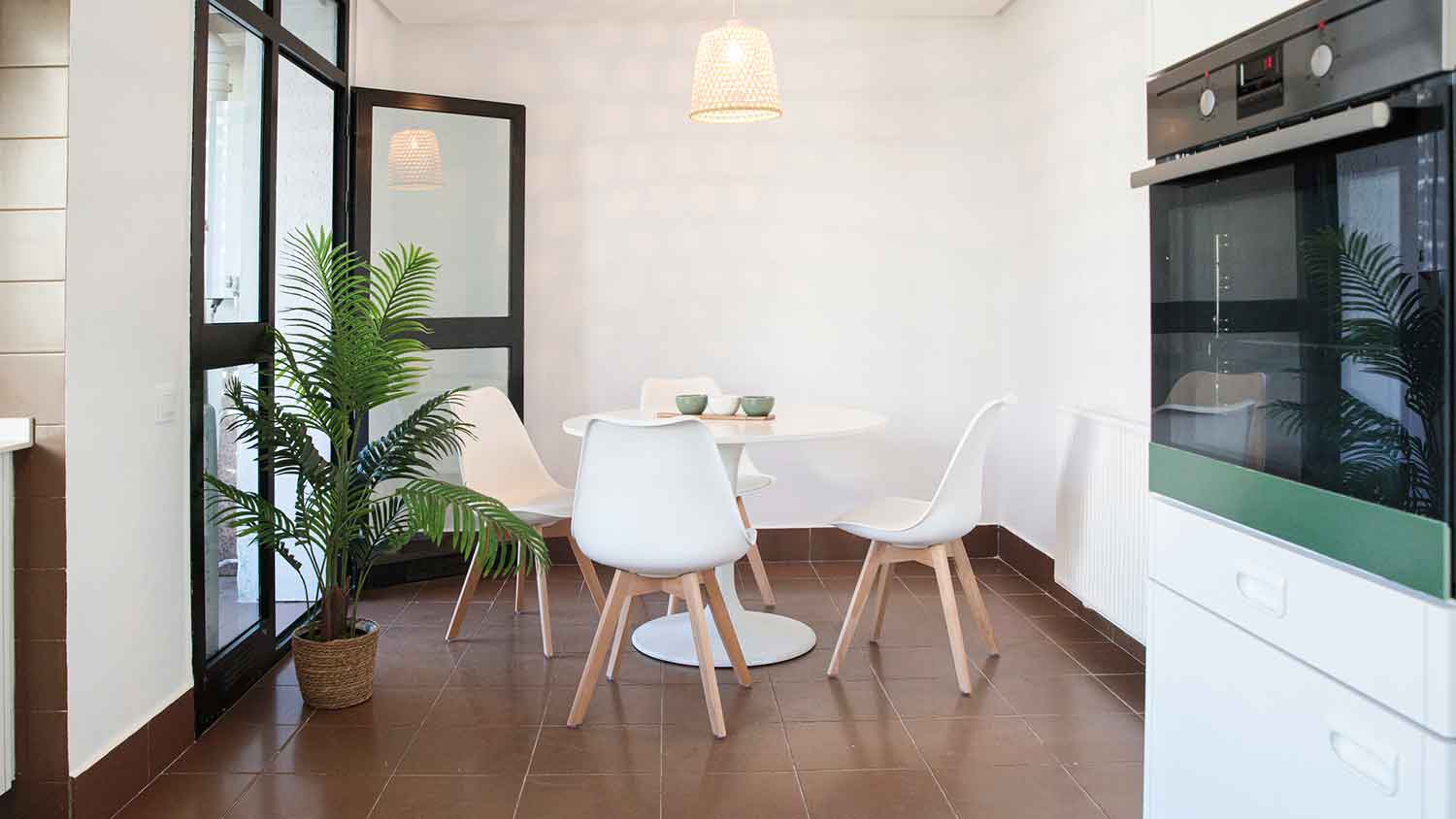 Dining room area with brown tiled floor and white walls