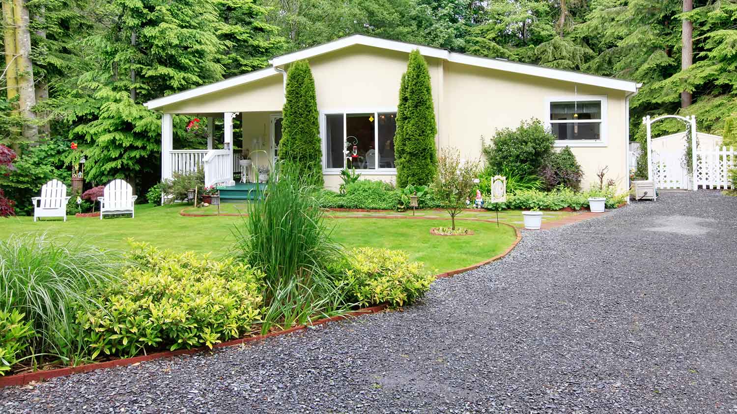 House surrounded by trees with a chip seal driveway