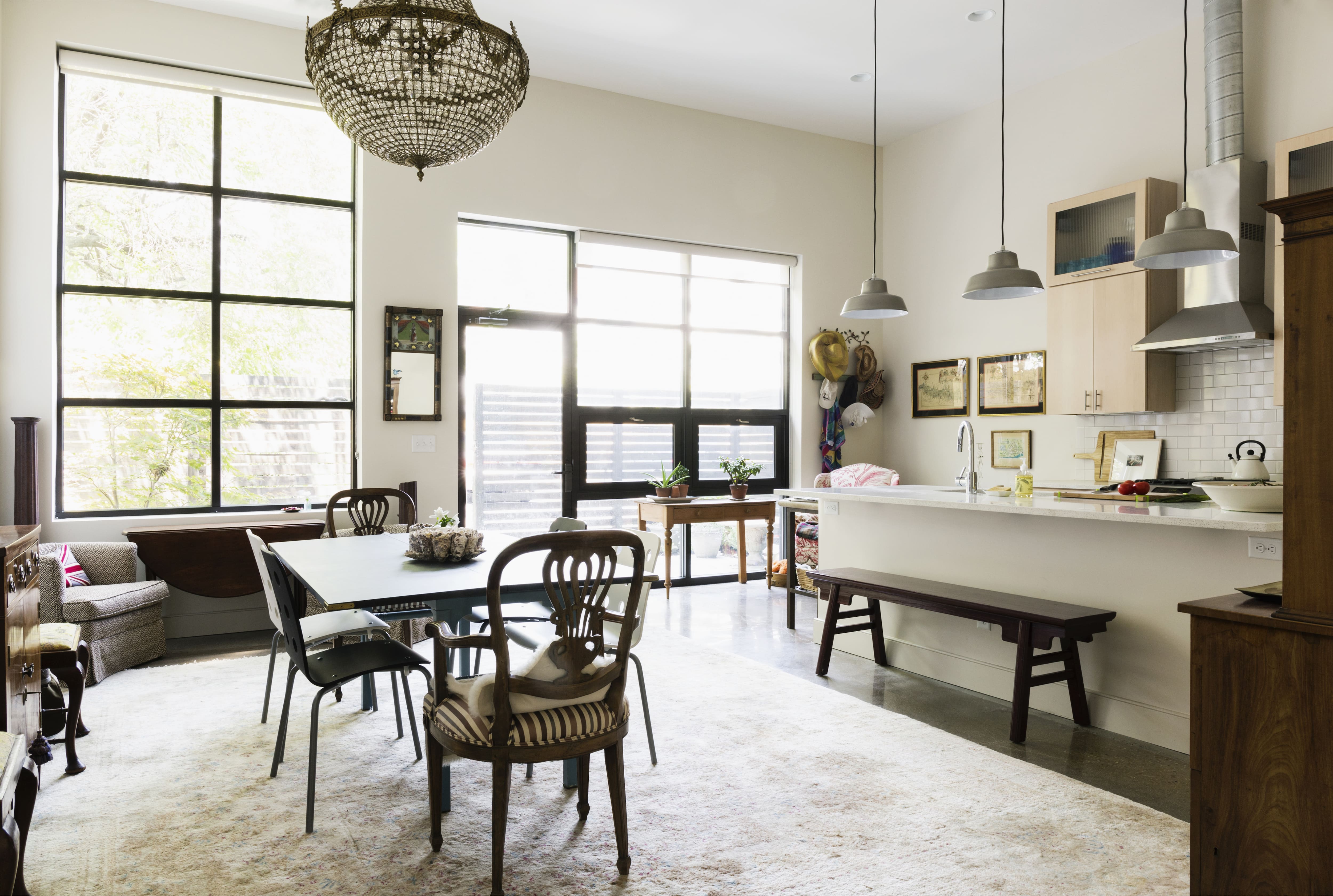 A kitchen with dining table on a white contrast rug