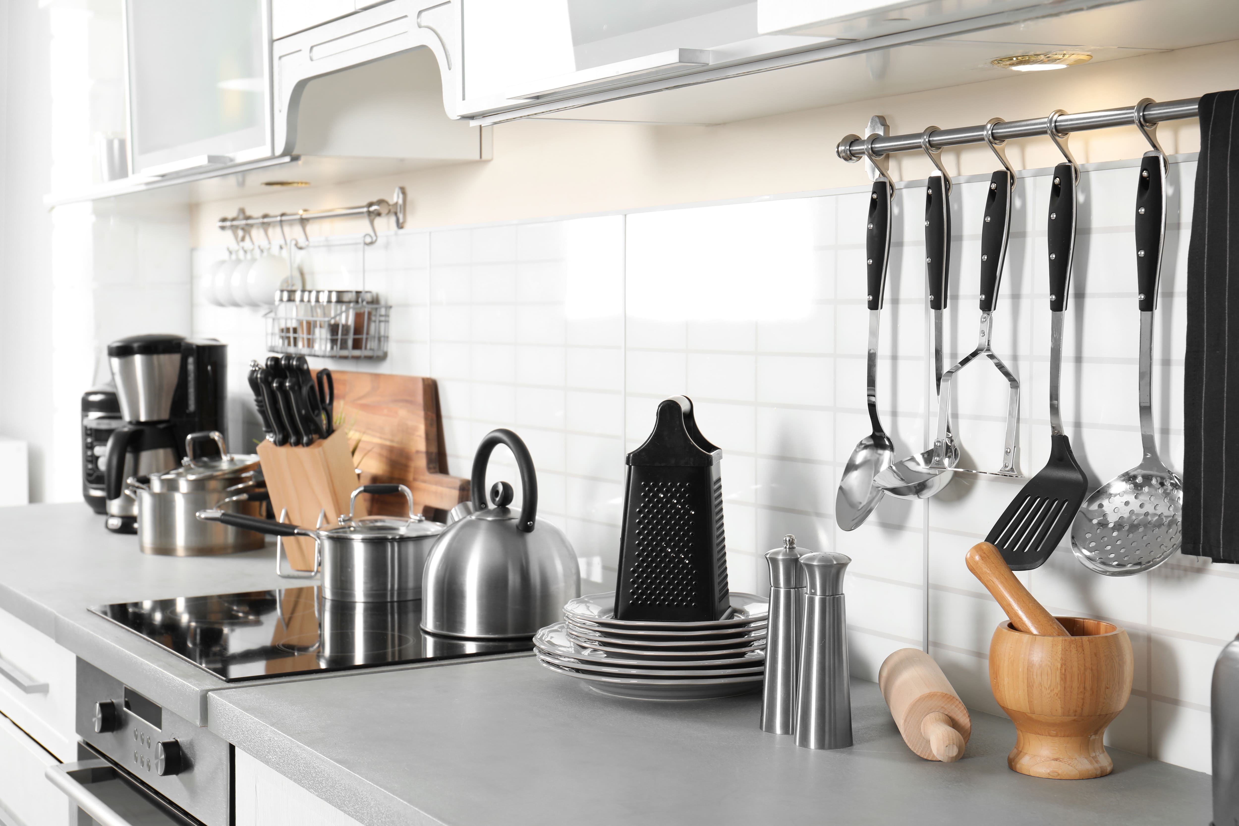 Stainless steel appliances displayed against a white kitchen backsplash