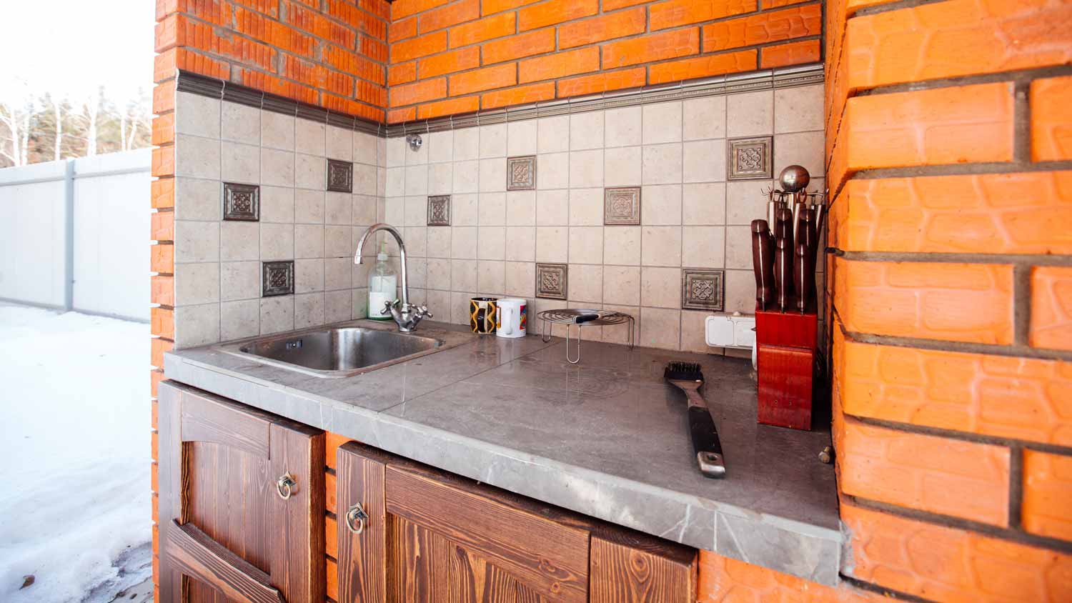 A small outdoor kitchen with wooden cabinets