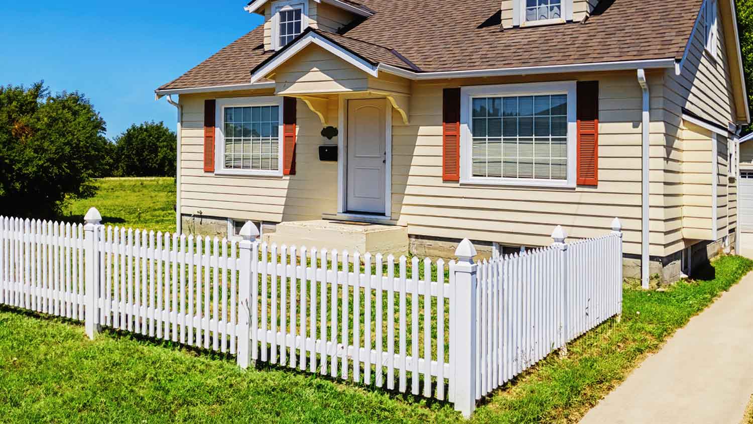 Small yellow house with white picket fence