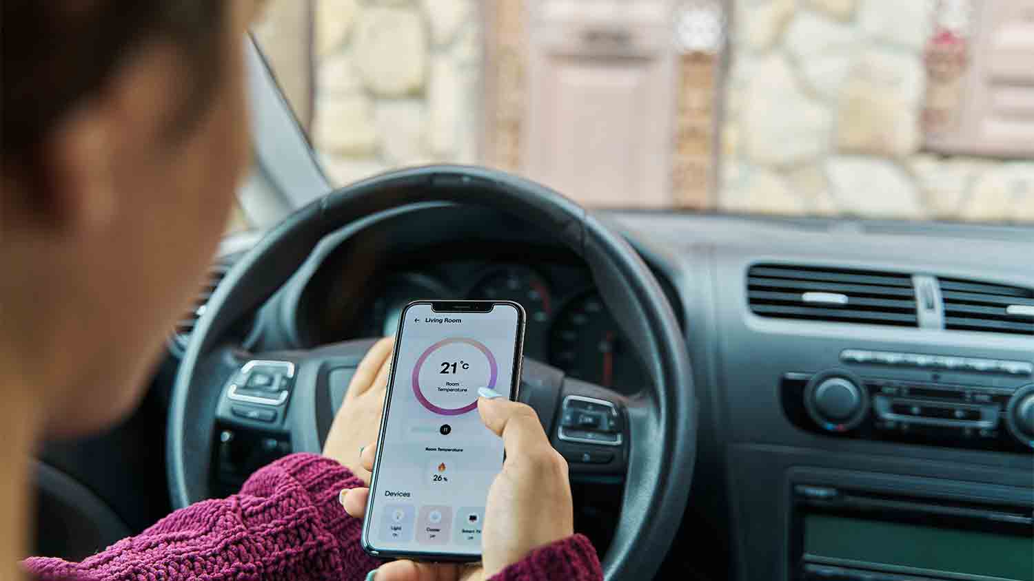 woman controlling home temp from car