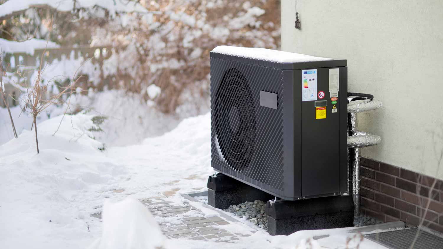 A snow covered AC unit in the exterior of a house