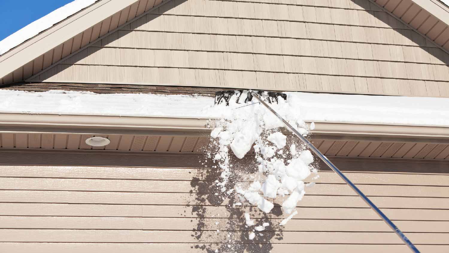 A snow rake removing snow from a roof