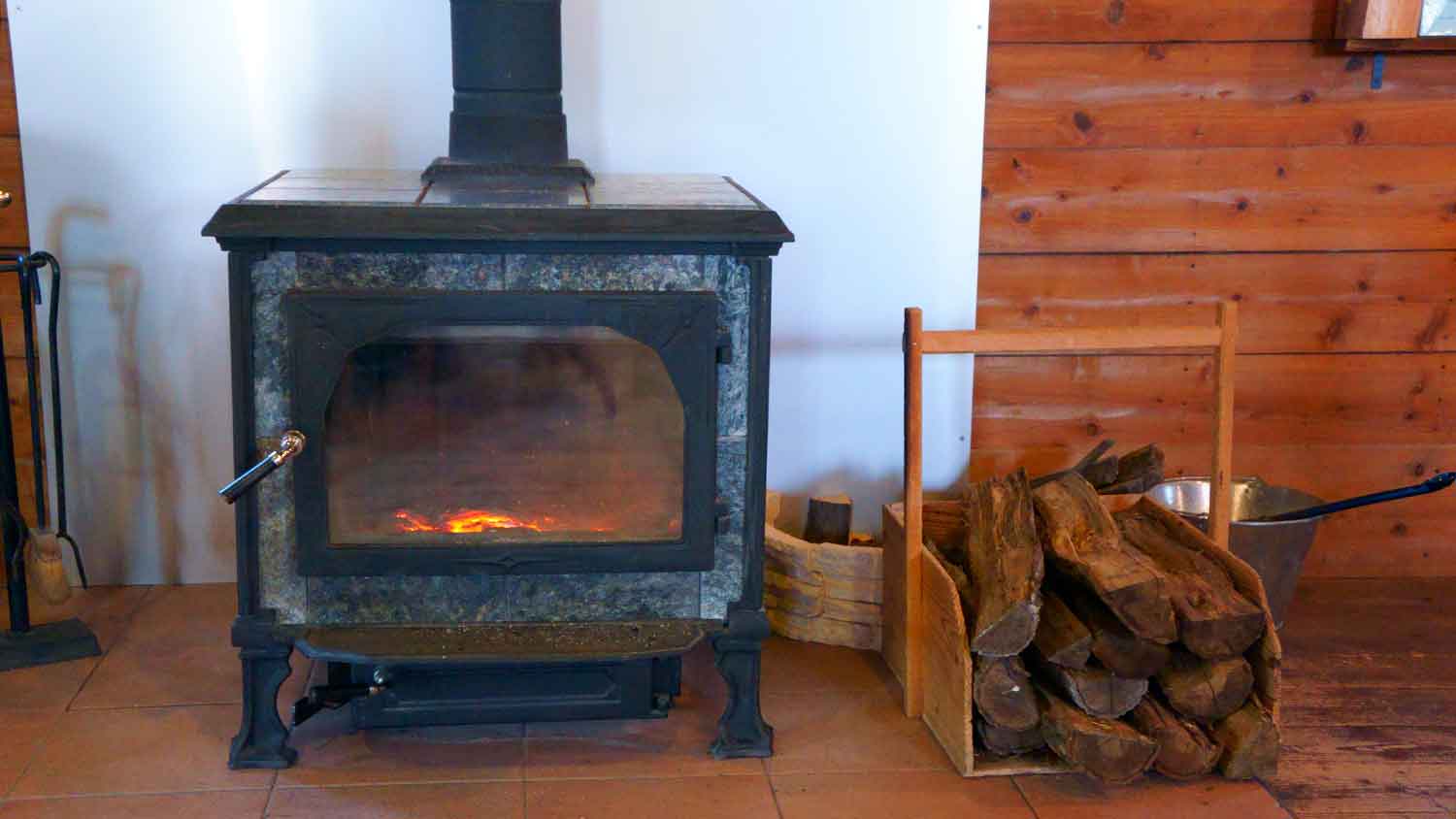 Soapstone wood stove sitting on a tile plank