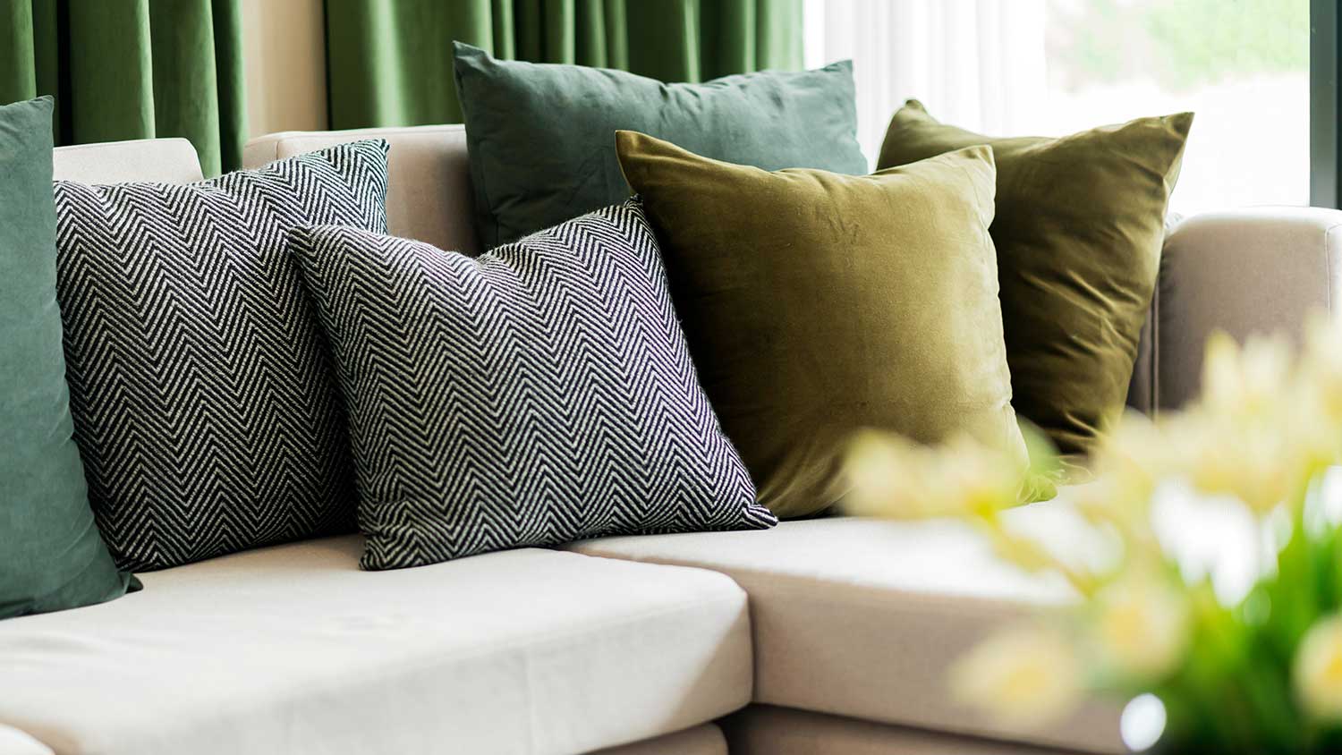 Closeup of a sofa with green and black pillows