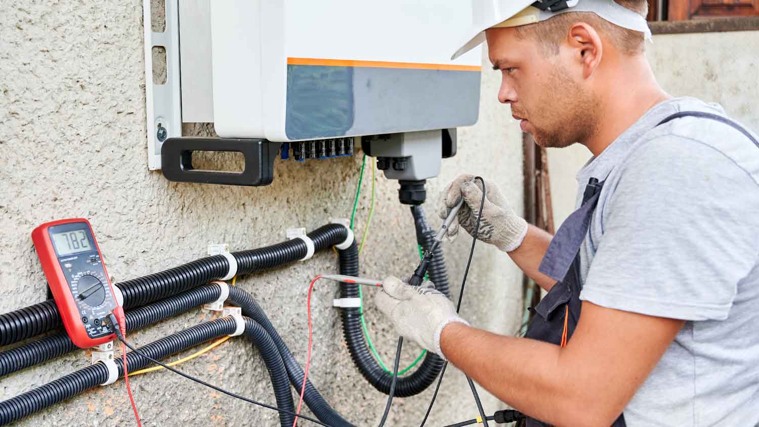 Electrician fixing solar panel inverter