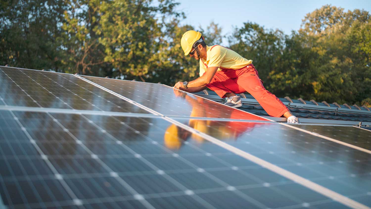 Solar technician repairing solar panel on the roof