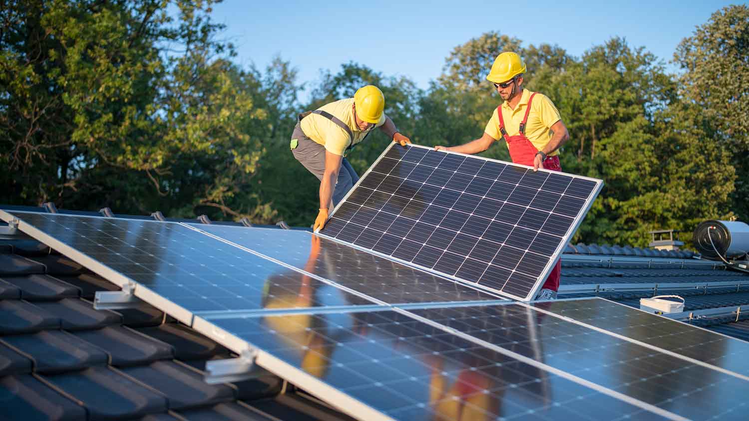 Solar technicians installing new solar panels on the roof