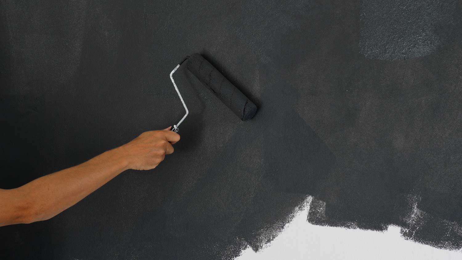 person using soundproof paint on wall