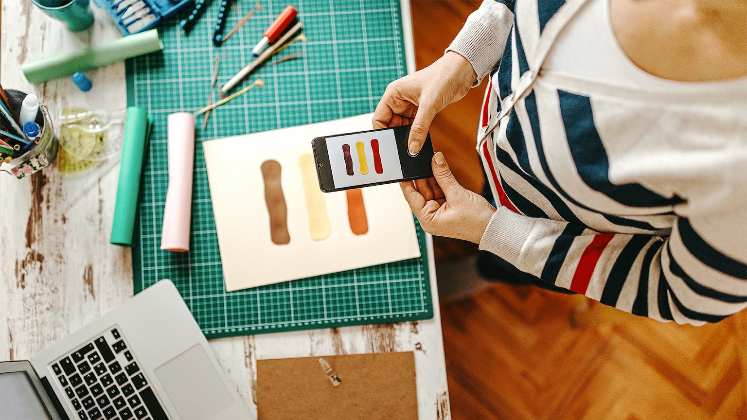 Woman photographing color sample on work desk