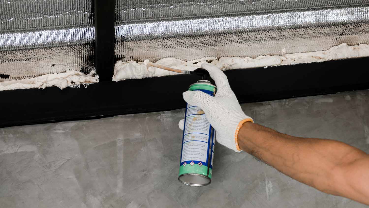 man using spray foam sealant