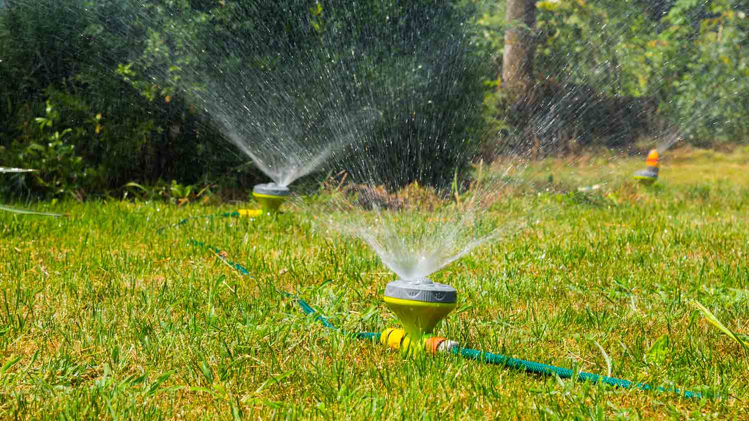 sprinkler spraying water on lawn  