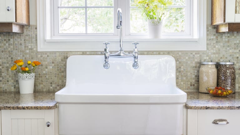 Large white kitchen sink and grey porcelain backsplash