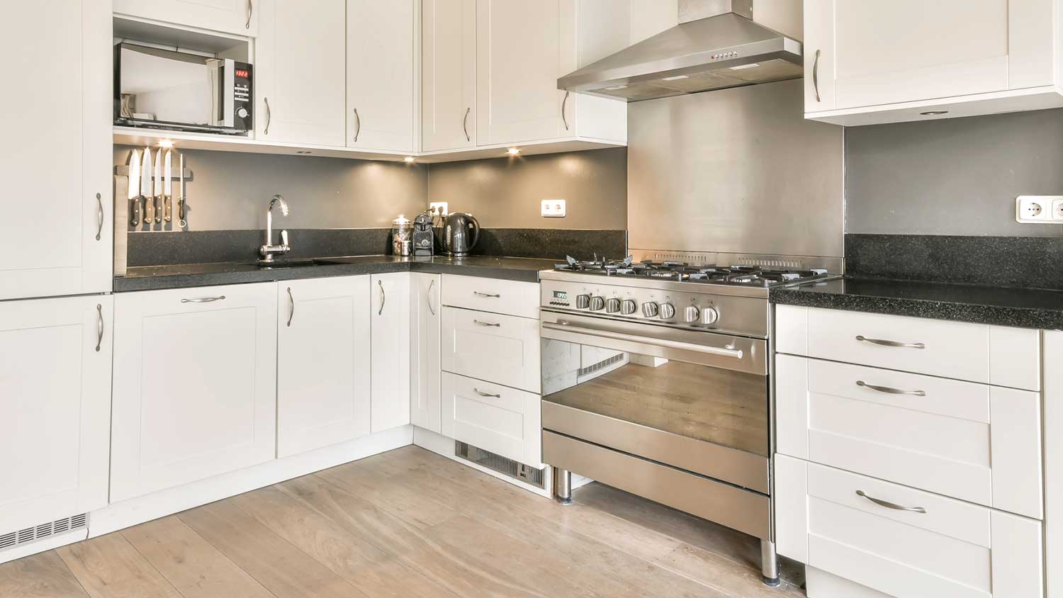Kitchen with white cabinets and gas range