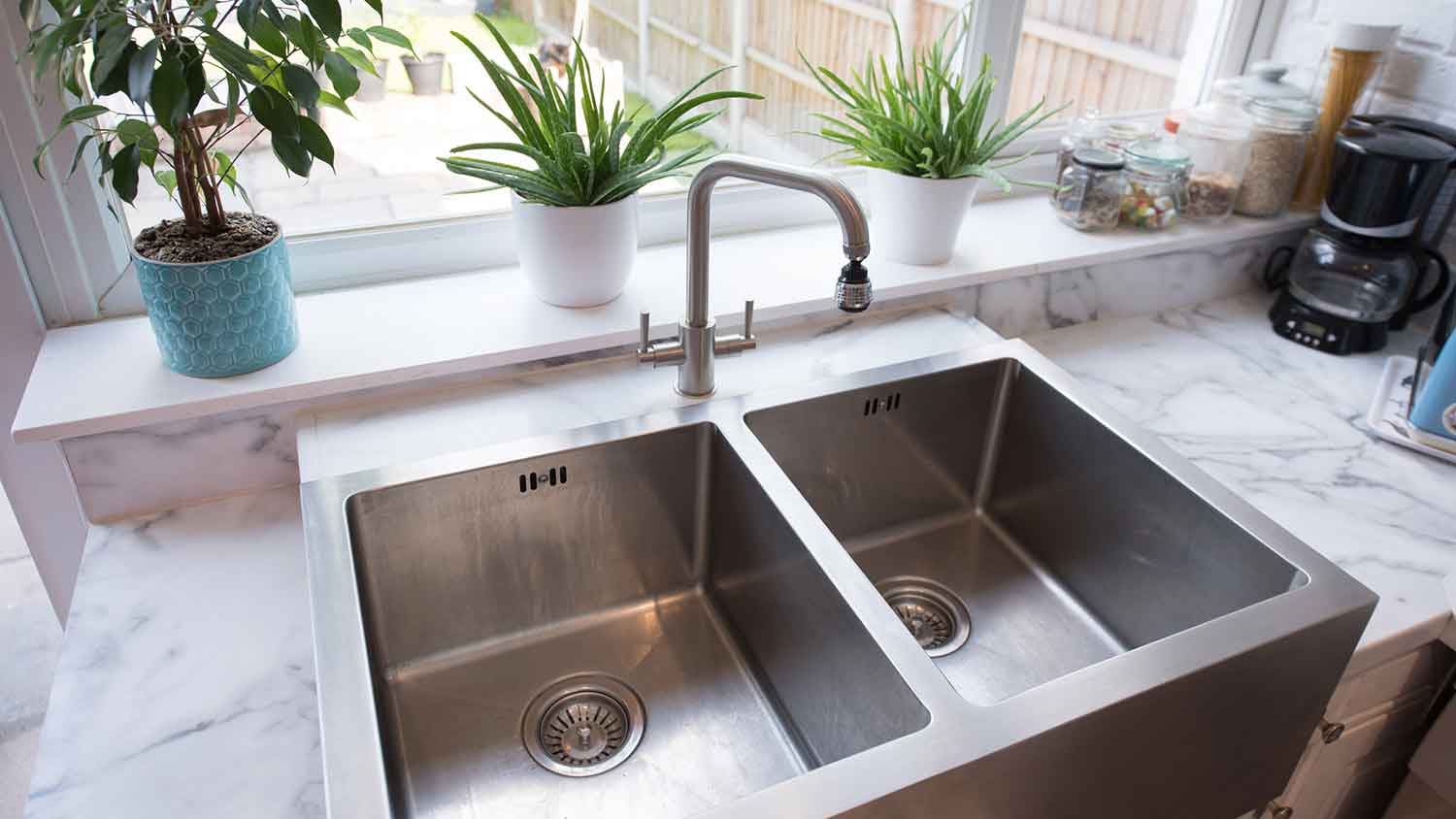 Kitchen with stainless steel sink and marble countertop