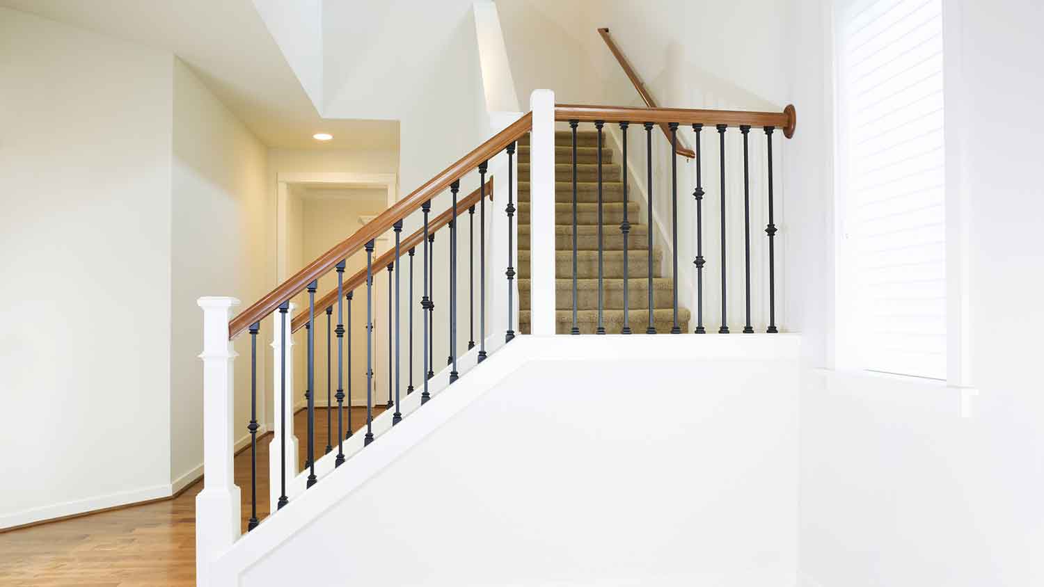 Staircase with iron balusters and wooden handrail