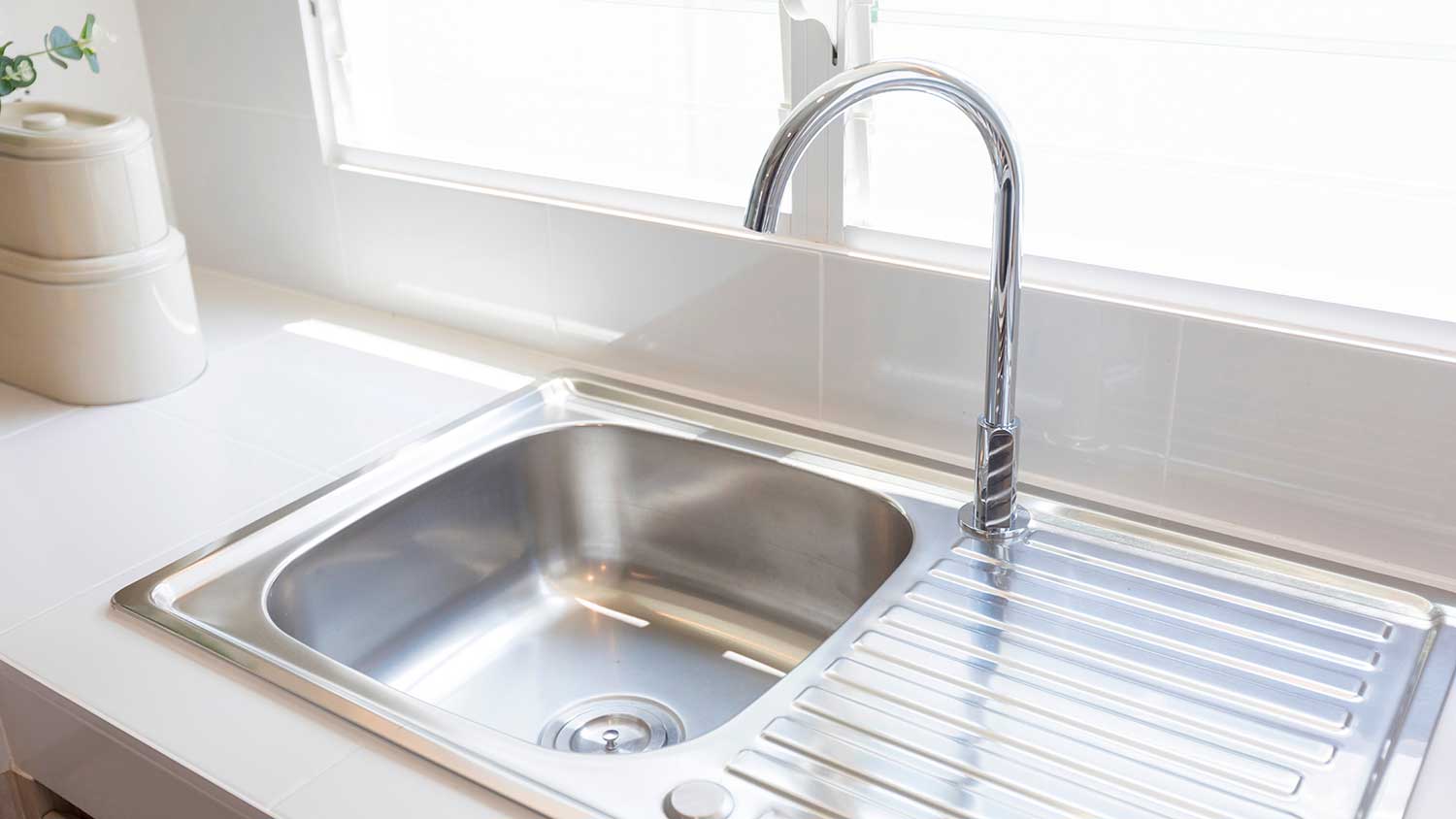 Stationary kitchen faucet installed on a stainless-steel sink