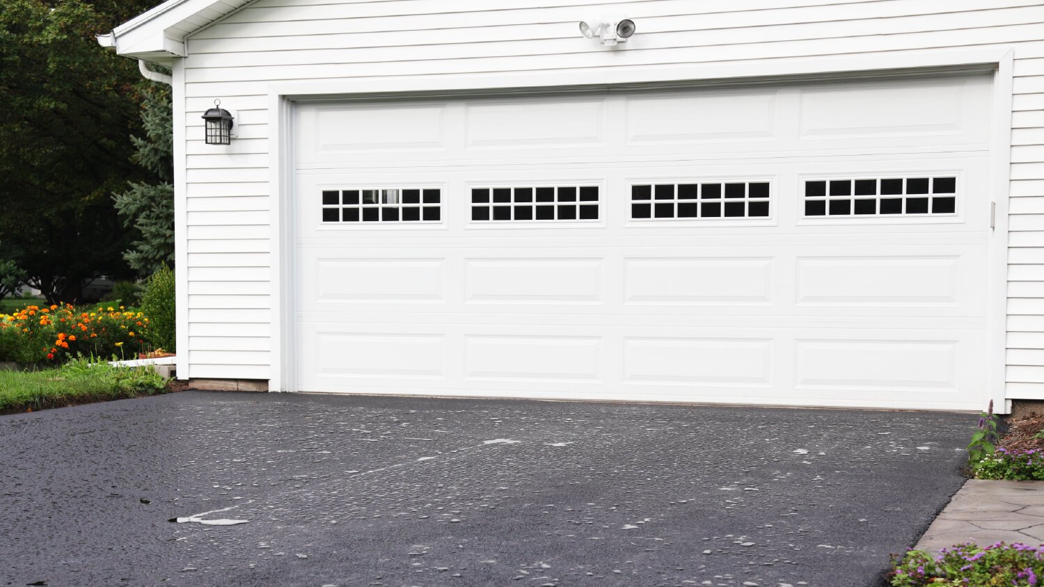 white steel garage door with white siding