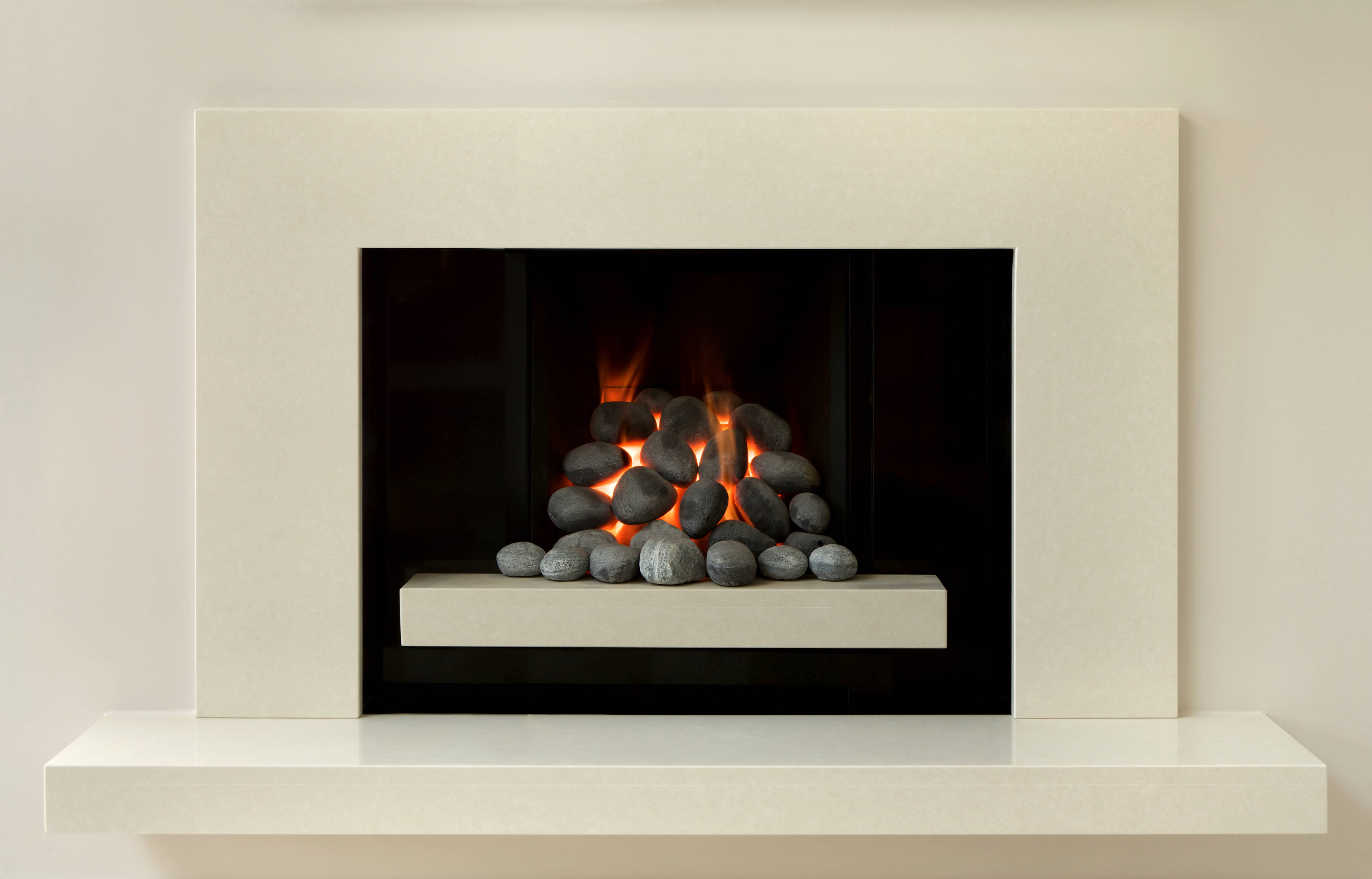 Modern white gas fireplace with round granite stones