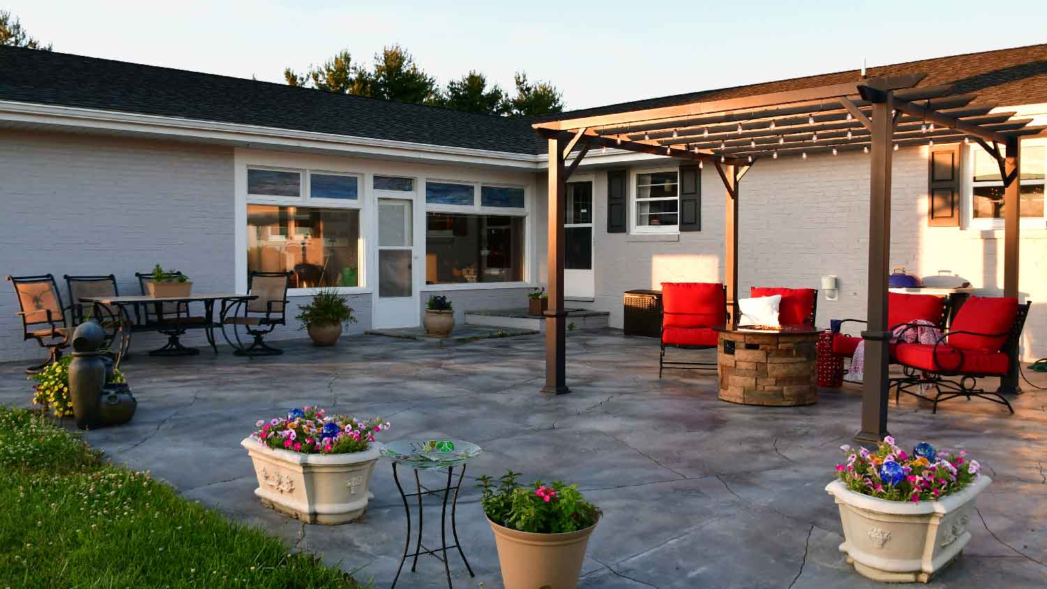 A stone fire pit under a pergola