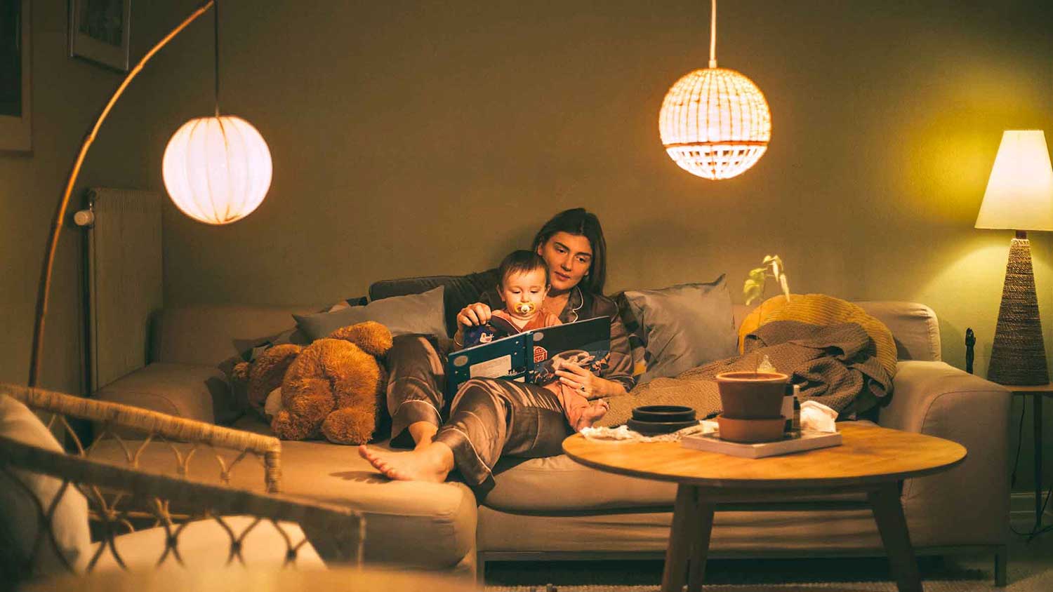 Mother reading a story to her little daughter at night 