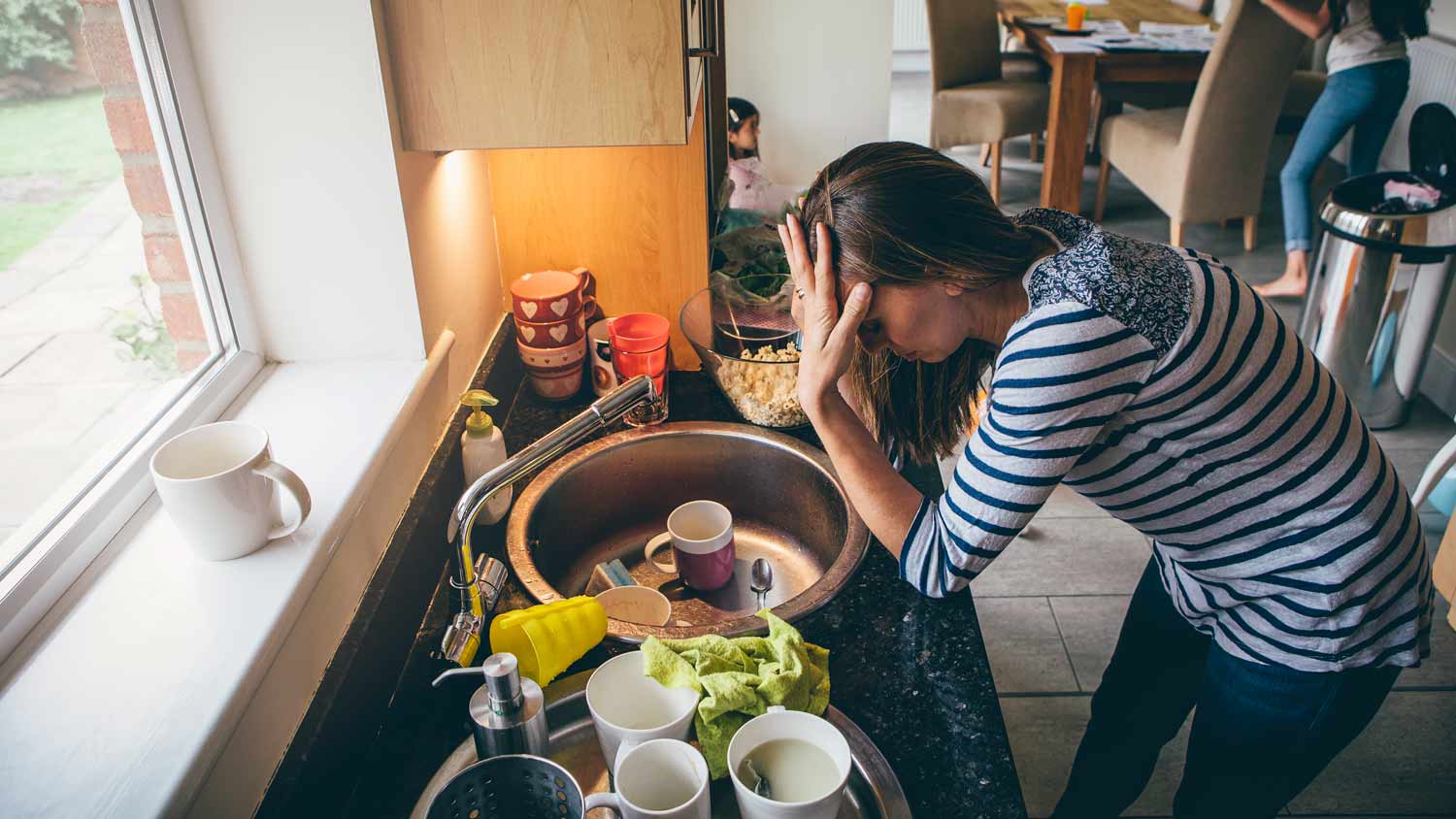 stressed woman in messy kitchen