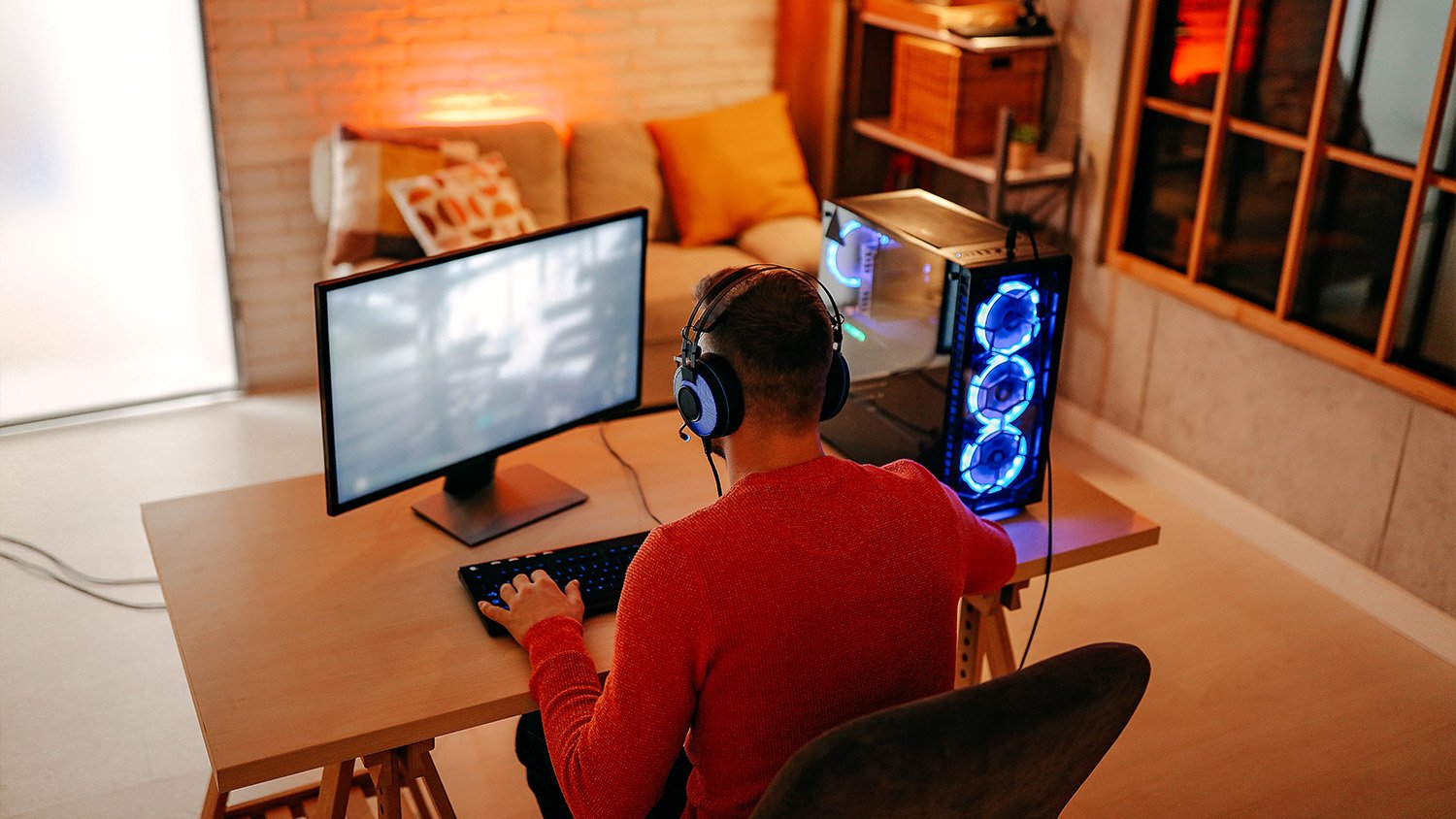 man sitting at desk playing video games