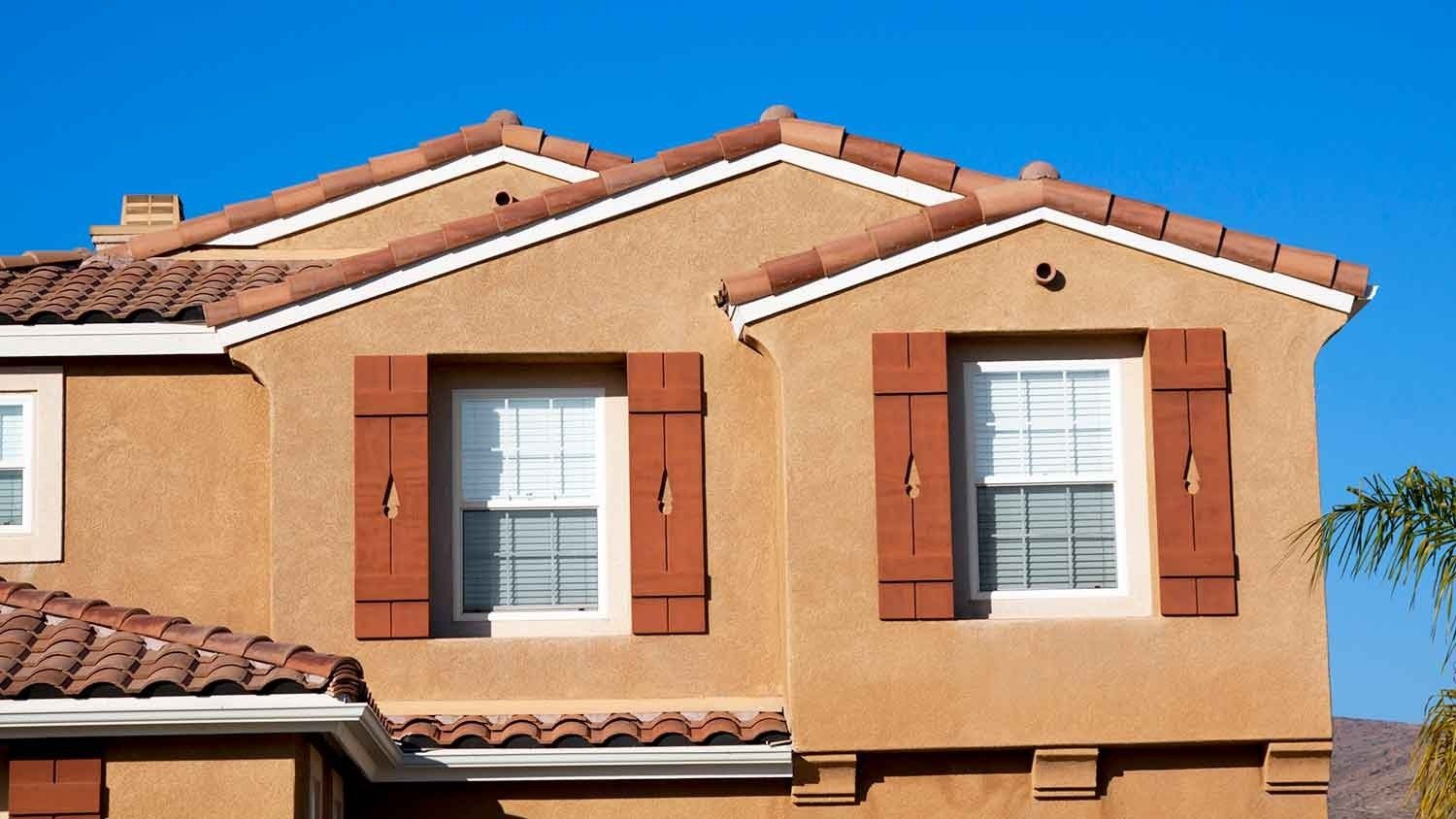 Stucco home with brown window shutters
