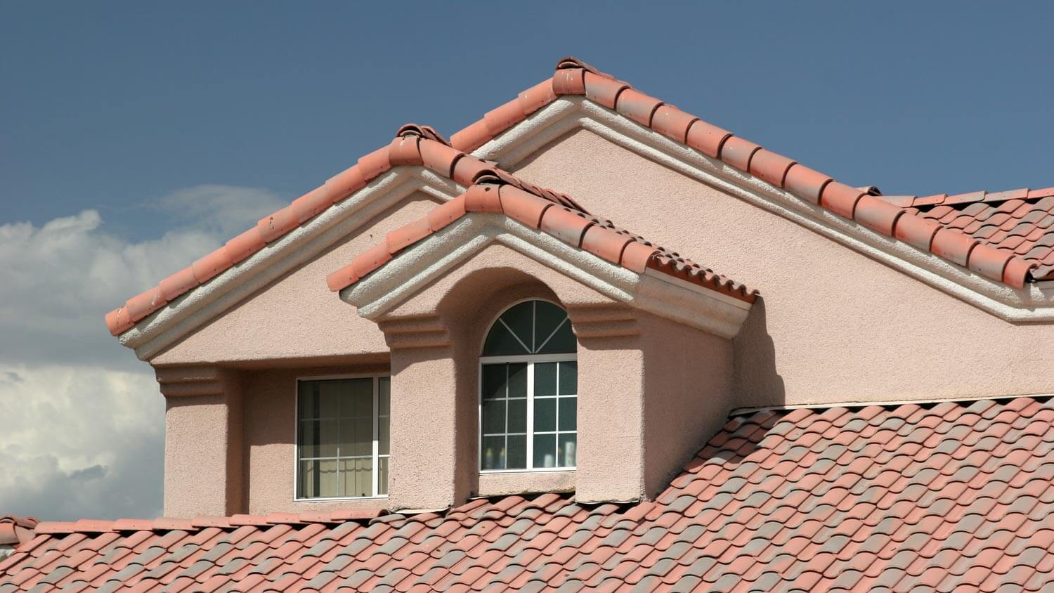 Detail of stucco siding on a house with tiled roof