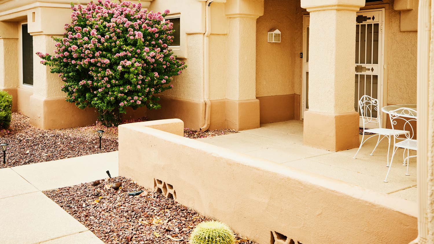 Desert style home with low stucco fence