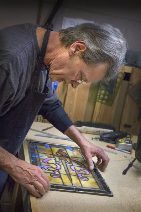 The Front Gate glass expert Gary Zelinger working on stained glass for a restored door