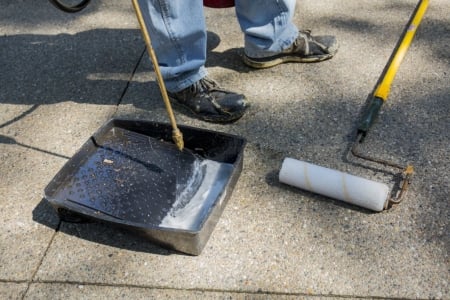Contractor holding driveway sealing tool