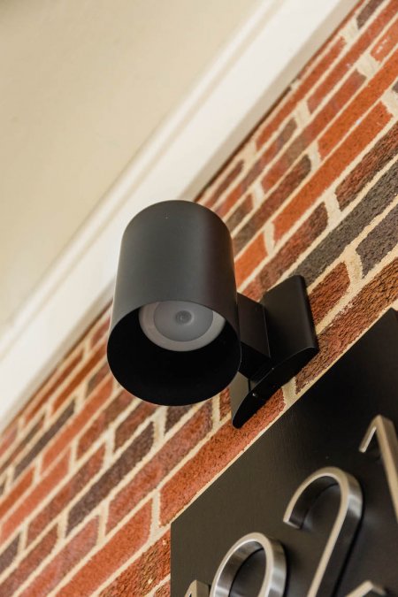 black cylindrical wall sconce against brick wall (Photo by © Carrie Waller)
