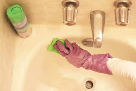 gloved hand scrubbing sink