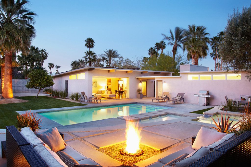 Pool with spa areas and fire pit with couch