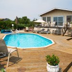 In-ground pool with wooden deck at beach house