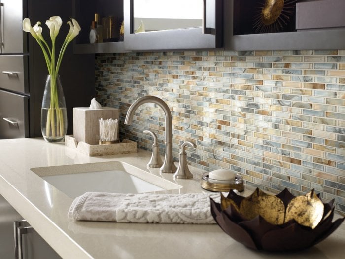 The blue tones of this tile backsplash complement the tans and browns of the other tiles, the counter and the cabinets. (Photo courtesy of Shaw Floors)