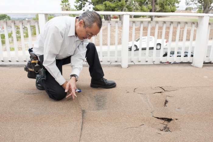 man inspecting a damaged deck