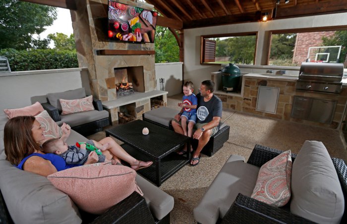 A family of four outside in their outdoor kitchen