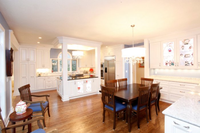 White kitchen with wood floors and table.