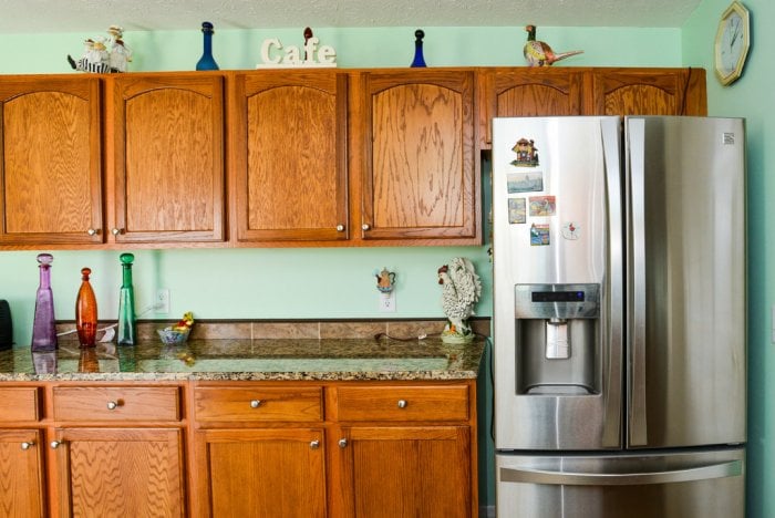 A kitchen with brown cabinets and a stainless steel refrigerator