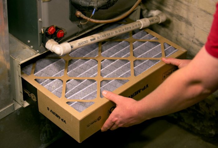 Someone replacing a home air filter